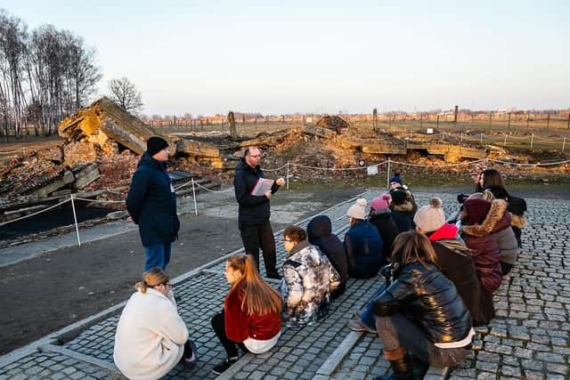 Students learn about the Holocaust in front of the partly demolished crematorium