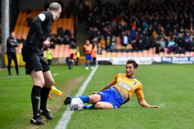 Mansfield Town's Will Atkinson slides to keep the ball in.