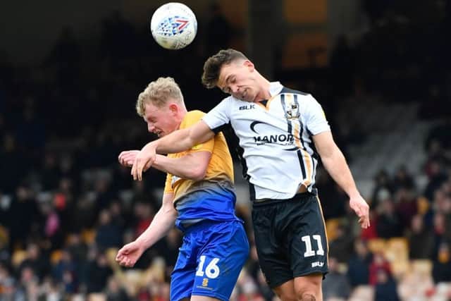 Port Vale's Luke Hannant competes for the ball with Mansfield Town's Willem Tomlinson.