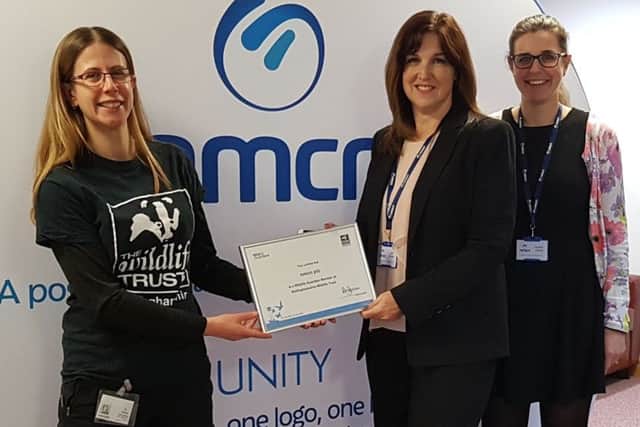 Holly McCain, of the trust, presents a certificate to mark nmcns support.