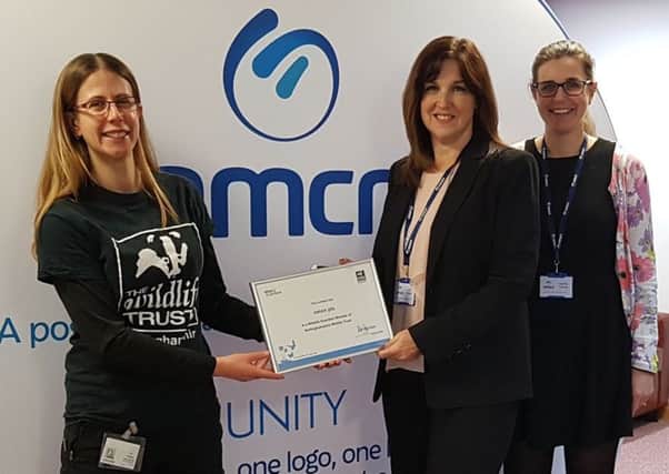 Holly McCain, of the trust, presents a certificate to mark nmcns support.