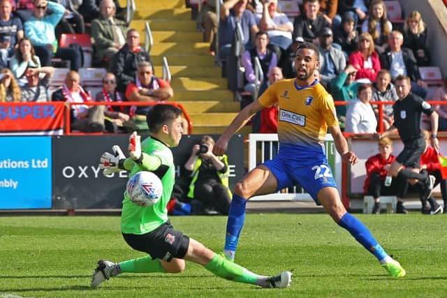 CJ Hamilton bends the ball past Exeter keeper Christy Pym to restore the Stags' lead