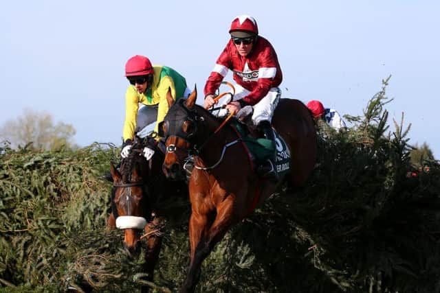 Tiger Rolls jumps to the front at the final fence, where runner-up Magic Of Light makes a mistake. (PHOTO BY: Alex Livesey/Getty Images).