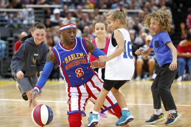 Firefly of the Globetrotters plays tricks with some kids. Photo by Daniel Munoz/Getty Images.