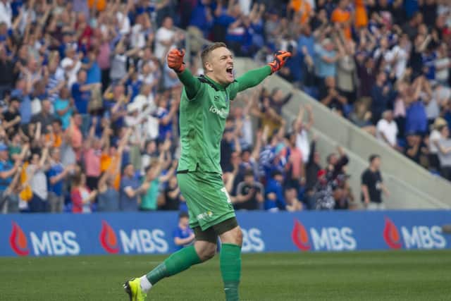 Oldham goalkeeper Daniel Iversen celebrates his sides third goal against Mansfield.