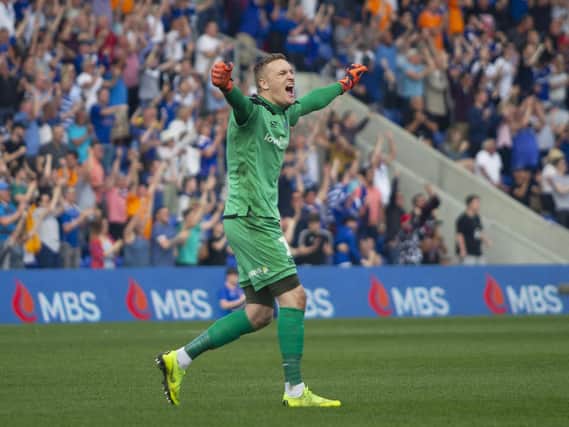 Oldham goalkeeper Daniel Iversen celebrates his sides third goal against Mansfield.