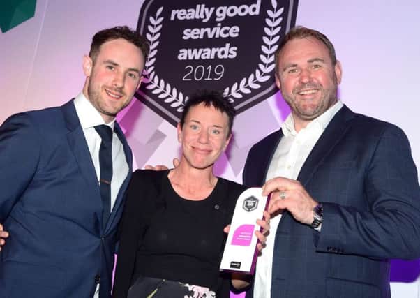 Caroline Webster receives her award from rugby legend Scott Quinnell (right) and Tom Morgan, of trentbarton.