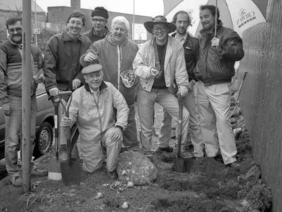 1989: These gents from Mansfield Lions Club brave the rain while doing a spot of bulb planting in the community. Did you take part in this?