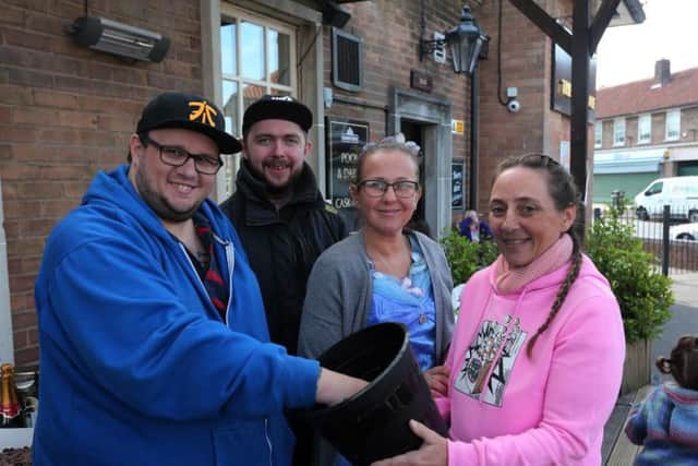 Teresa Skeavington holds the raffle prize bucket as Daniel Skeavington draws a number. L/R: Daniel Skeavington, Ryan Crowder, Stephanie Abdin, Teresa Skevington.