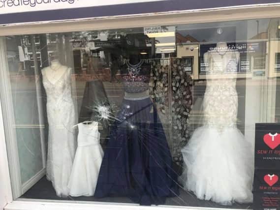 The bridal dresses in the window were covered with shards of broken glass.