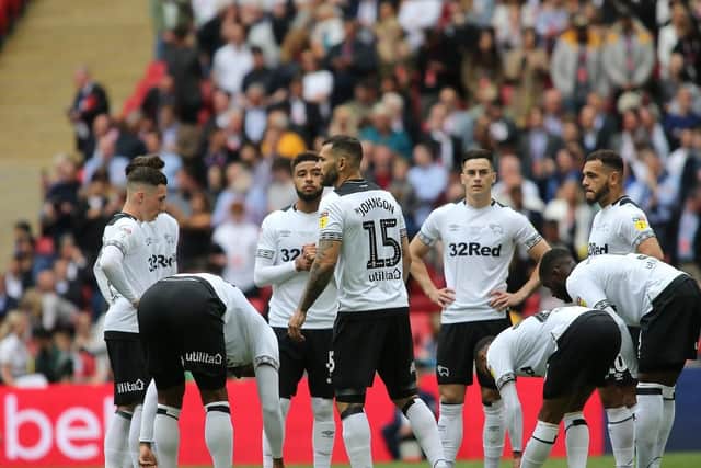 Derby County's player gather after falling behind.