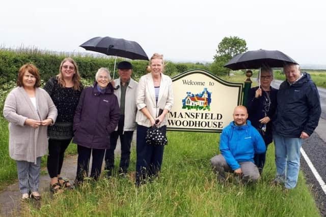 Councillors and members of the Mansfield Woodhouse Community Development Group pictured with the new 'Welcome to Mansfield Woodhouse' sign, on Peafield Lane.