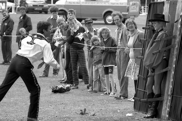 1989: Onlookers are watching intently at this knife throwers action at the Mansfield Show. Did you see this act?