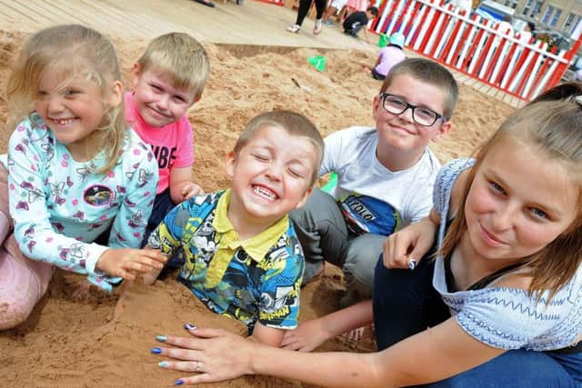 Alfie Whitehead lets his siblings and cousins plant him in the sand,from left, Brooklyn-Gray Whitehead,Harrison Hyatt, Braidon Whitehead, and 12 year old Chardonnay Hyatt at last year's beach