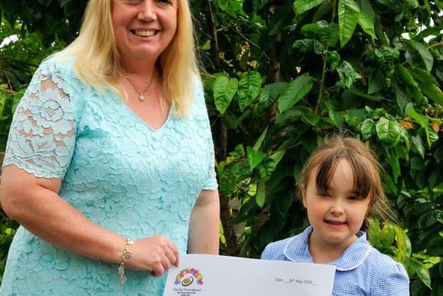 Tabitha receiving a cheque from the school's head teacher, Kim Tucker. (PHOTO BY: Louise Brimble)