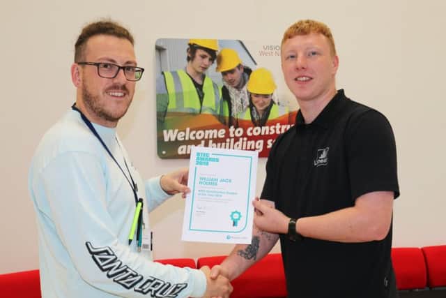 Will Holmes (right) is presented with his award by tutor Adam Thompson