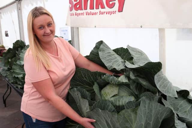 Laura Litchfield shows off a giant cabbage grown by her partner Chris Marriott.