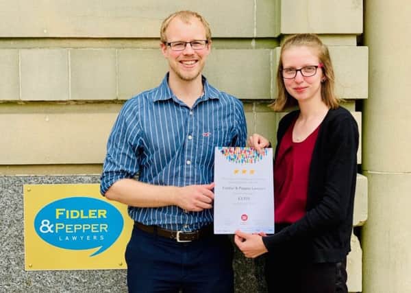 Emma Grieves, of Fidler & Pepper, receives the certificate from Tom Wyke, of Christian Aid.