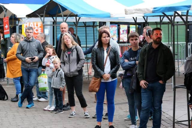 Spectators watch the runners pass through the market place.