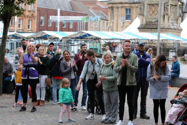 Spectators applaud as the runners pass through the market place.