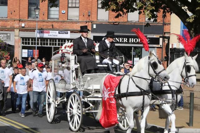 His coffin was carried in a horse drawn carriage and draped in the colours of his belovedLiverpool FC.