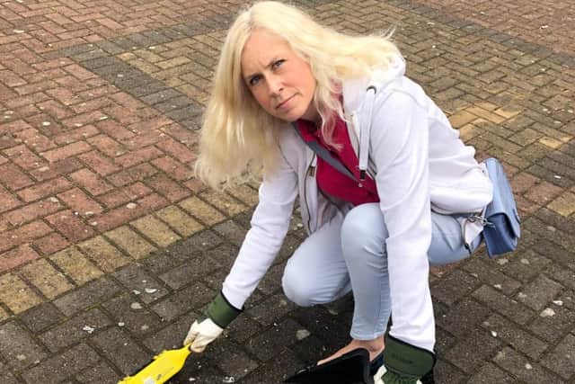 Councillor Melanie Darrington cleaning up broken glass in Skegby.