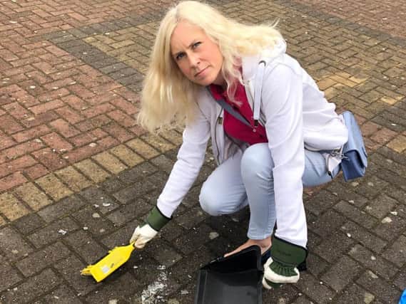 Councillor Melanie Darrington cleaning up broken glass in Skegby.