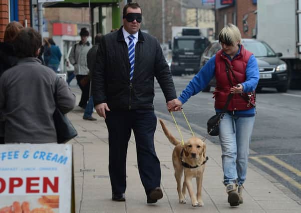 MP Mark Spencer takes to the streets of Hucknall blindfolded, working with the Guide Dogs for the Blind Association.  MP Mark Spencer pictured with Guide Dog Mobility Instructor Laraine Wakelin.