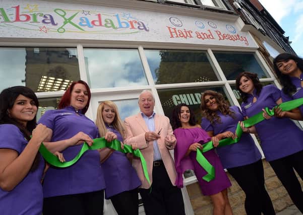 Mansfield Mayor Tony Egginton cuts the ribbon with owner Alejandra Cooling-Valencia and her staff at the opening of Abrakadabra Hair and Beauty on Church Side in Mansfield on Saturday.