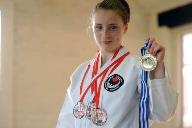 Bailey Lowe (18) won a silver medal in kata and 2 bronze in kumite at the 2013 WIKF world karate championships in Crawley, pictured here with her medals and Mansfield Karate Club.