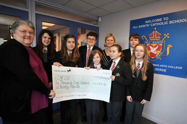 Students at All Saints Catholic School have been fundraising for CAFOD, raising over £6,000 from various activities. Pictured are year 11 and 12 students and assistant chaplin presenting a cheque to Marie Molloy of CAFOD (NMAC-17-01-14 RA 1a)