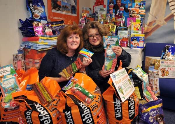 Presentation of pet food to the RSPCA donated by staff and customers of Co-op Travel, pictured are from left fundraiser Wendy Mclaren and RSPCA representative Shelley James (NHUD-21-01-14 RA 1a)