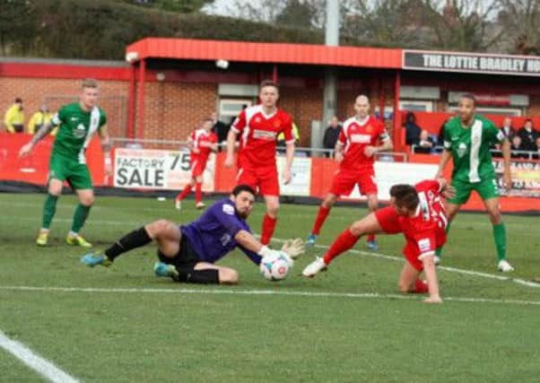 Lincoln keeper Nick Townsend dives to stop Shaun Harrad.