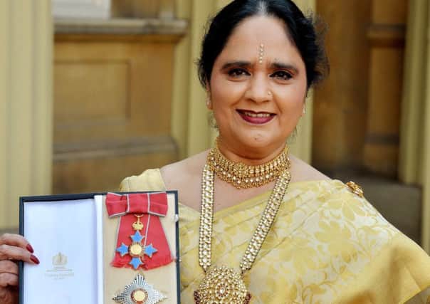 Dame Asha Khemka proudly shows off her insignia of Dame Commander of the British Empire.
