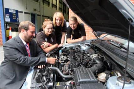Senior road safety officer Neil Snow explains whats under the bonnet of the modern car to students Phoebe Brough, Ebony Smith, Alice West.