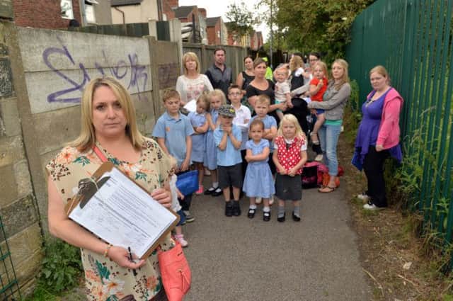 Parents of children at Priestic Primary School are campaiging to get the footpath closed due to anti-social behaviour, pictured are  Paula Hallam with petition and children and parents on the footpath