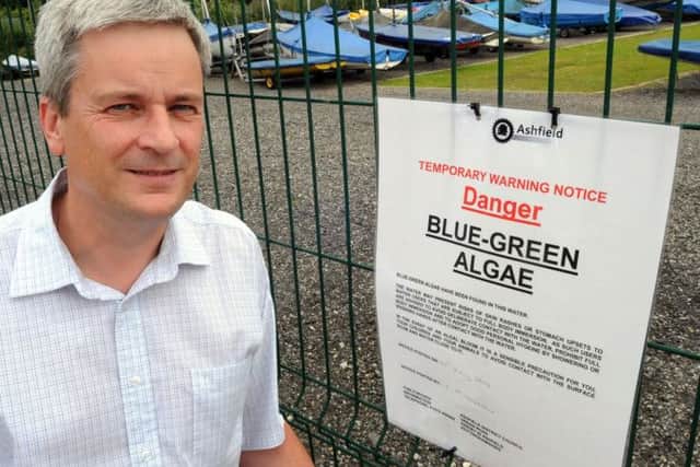 Dale Clarke alongside one of the signs warning visitors to Kings Mill Reservoir about the algae.