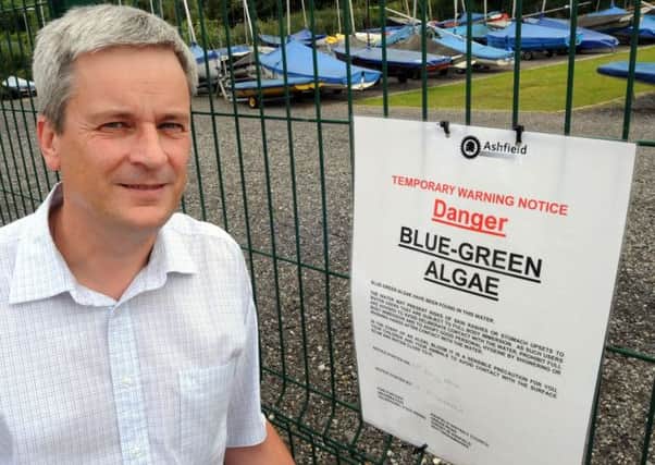 Dale Clarke alongside one of the signs warning visitors to Kings Mill Reservoir about the algae.