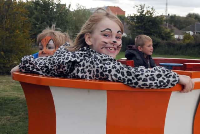 Caitlin Hardy-Caddick and Harley Bell enjoy a teacup fairground ride.