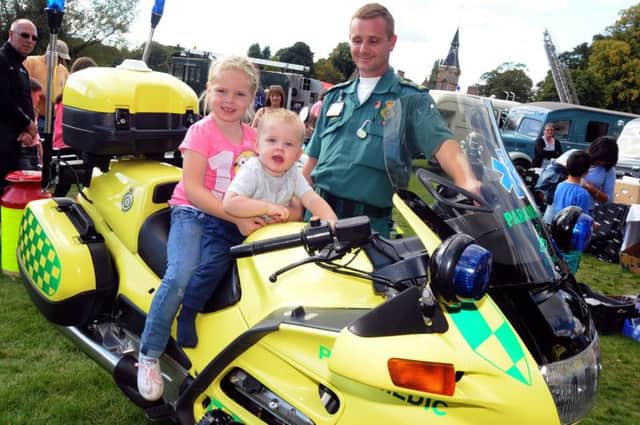 Emergency care assistant, Paul Prehn, keeps an eye on Ollie and Meeya Bramley who got on one of the heritage bikes on display.