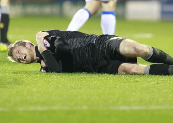 Alex Fisher feels the pain after challenging for the ball -Pic by: Richard Parkes