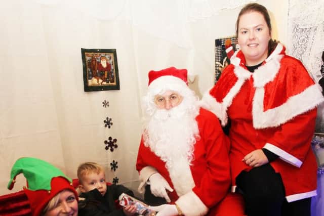 Keycraft Garden Buildings in Hucknall are having a Santa's Grotto in December with proceeds going to Hayward House Hospice and Wish Upon A Star. Blase Hallam, two, is pictured with Santa. nhud-24-11-14 santa huc(2)
