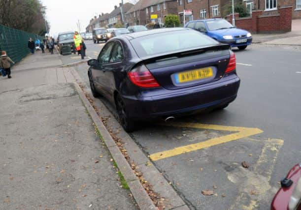 A parent parks in a restricted zone outside Wainwright Primary School at going home time.
