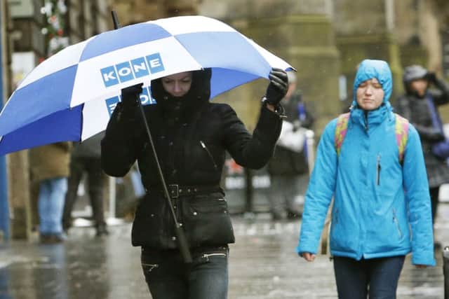 A woman with an umbrella on the Royal Mile in Edinburgh as Britain is set to battered by a "weather bomb". PRESS ASSOCIATION Photo. Picture date: Tuesday December 9, 2014. Widespread weather warnings have been issued as a so-called "weather bomb" is set to batter parts of Britain. Winds of around 80 miles per hour are expected to hit the UK this evening, with severe gales expected across north Wales, Scotland, northern England and Northern Ireland for about 48 hours. See PA story WEATHER Cold. Photo credit should read: Danny Lawson/PA Wire