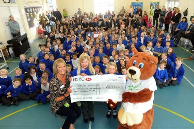 Ruby gets help from her sister Kitty with handing over the huge  cheque to Ashgate Hospicecare fundraiser Lynn Jones and Ashley Bear at her Longstone school.