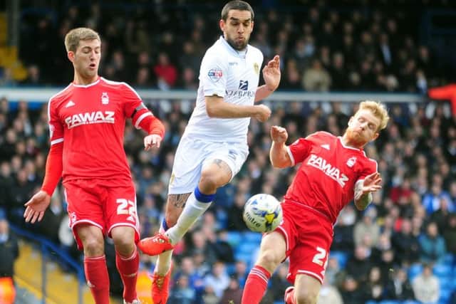 Giuseppe Bellusci goes past the challenge of Forest players Gary Gardner and Chris Burke.