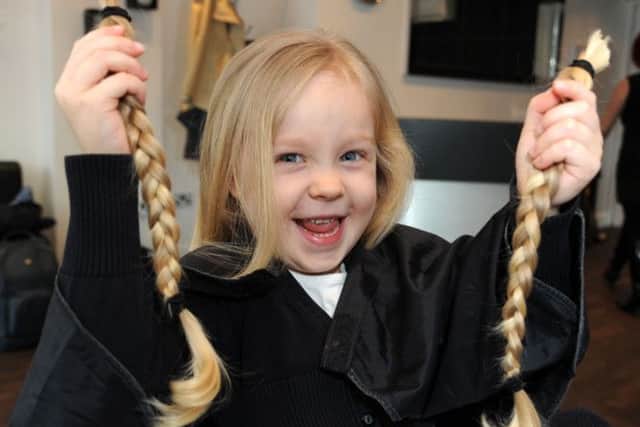 Frankie Walters holds up her plaits which she will donate to the Little Princess Trust.