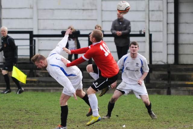 Eastwood striker Matt Clowes (in red) challenges for possession