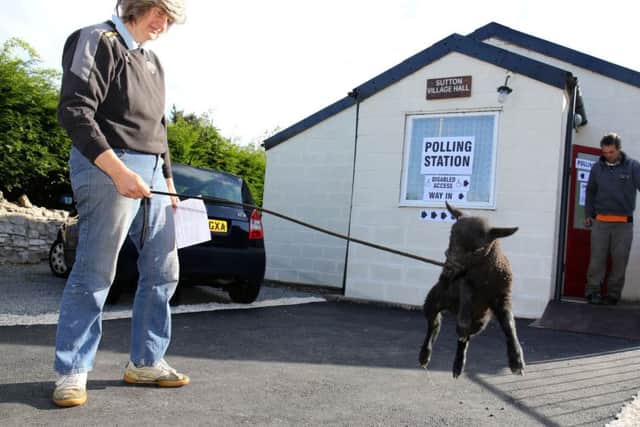 Judith Preston walks her pet lamb Beth as she attends Sutton village hall in Doncaster to cast her vote