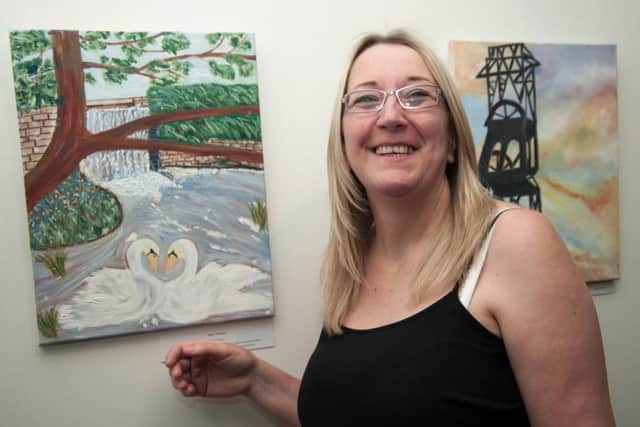Parent Dawn Tomlinson displays her work a collaboration between Samworth Church Academy students and their parents in an art exhibition at Mansfield library inspired by the local Mansfield landscape.